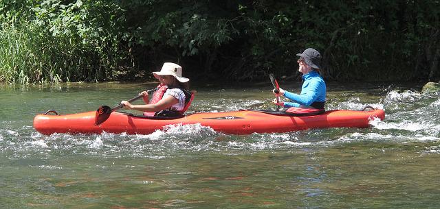 A man and a woman kayaking. It takes less effort when you go downstream, But you need to first find your flow. And to find your inner flow, you must stop trying too hard.
