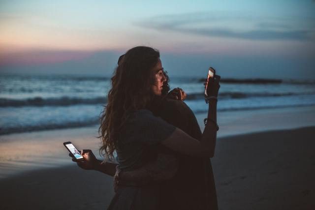 a couple hugging and using smart phone near sea on sunset. 

Psychologists suggest that boredom is a warning sign that our mind sends, indicating that something is not right and that we need to act. It is how we deal with boredom that determines whether it has a positive or a negative impact on us." www.gauravsinhawrites.in